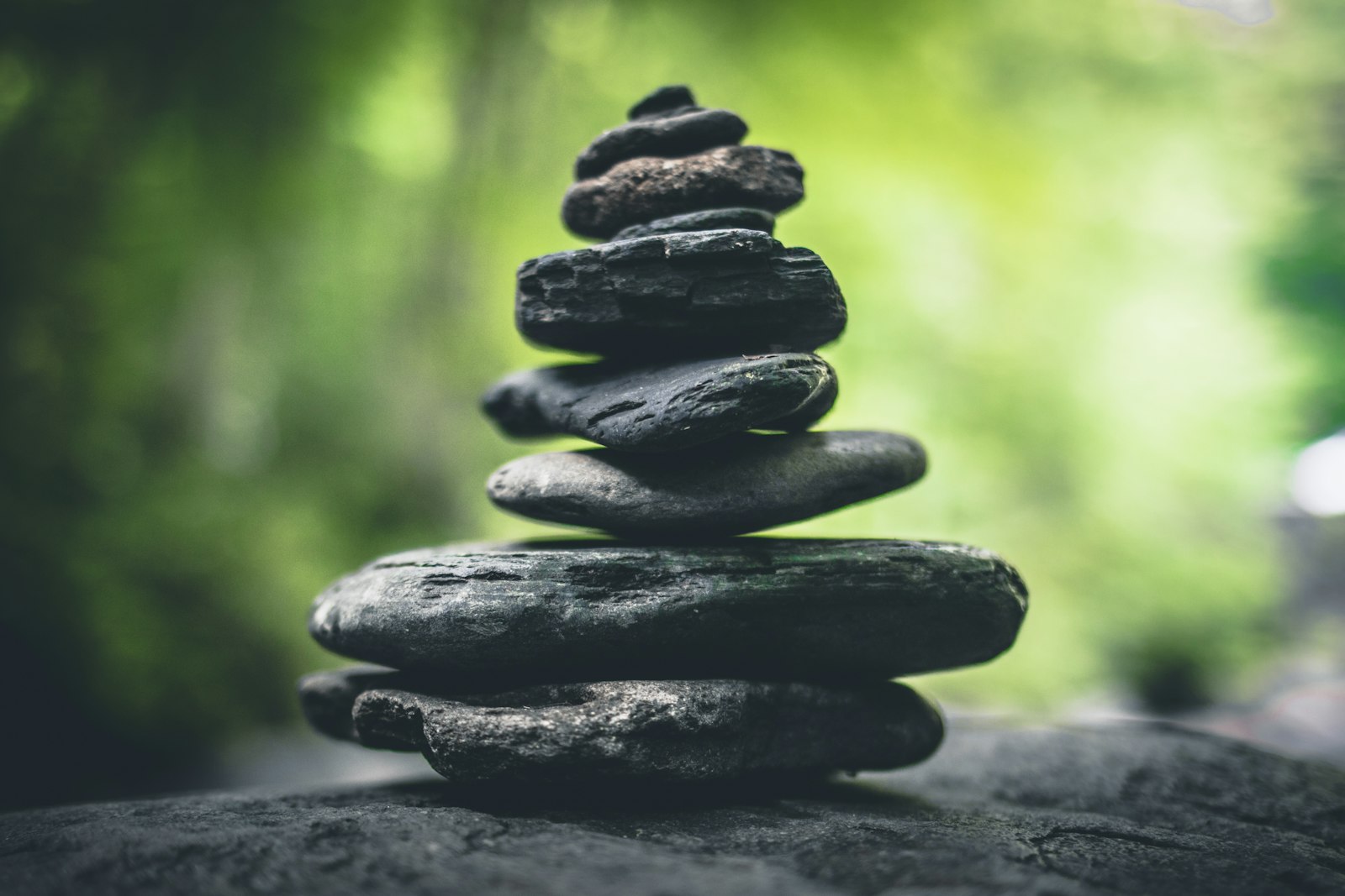 Balanced stone cairn, forest light